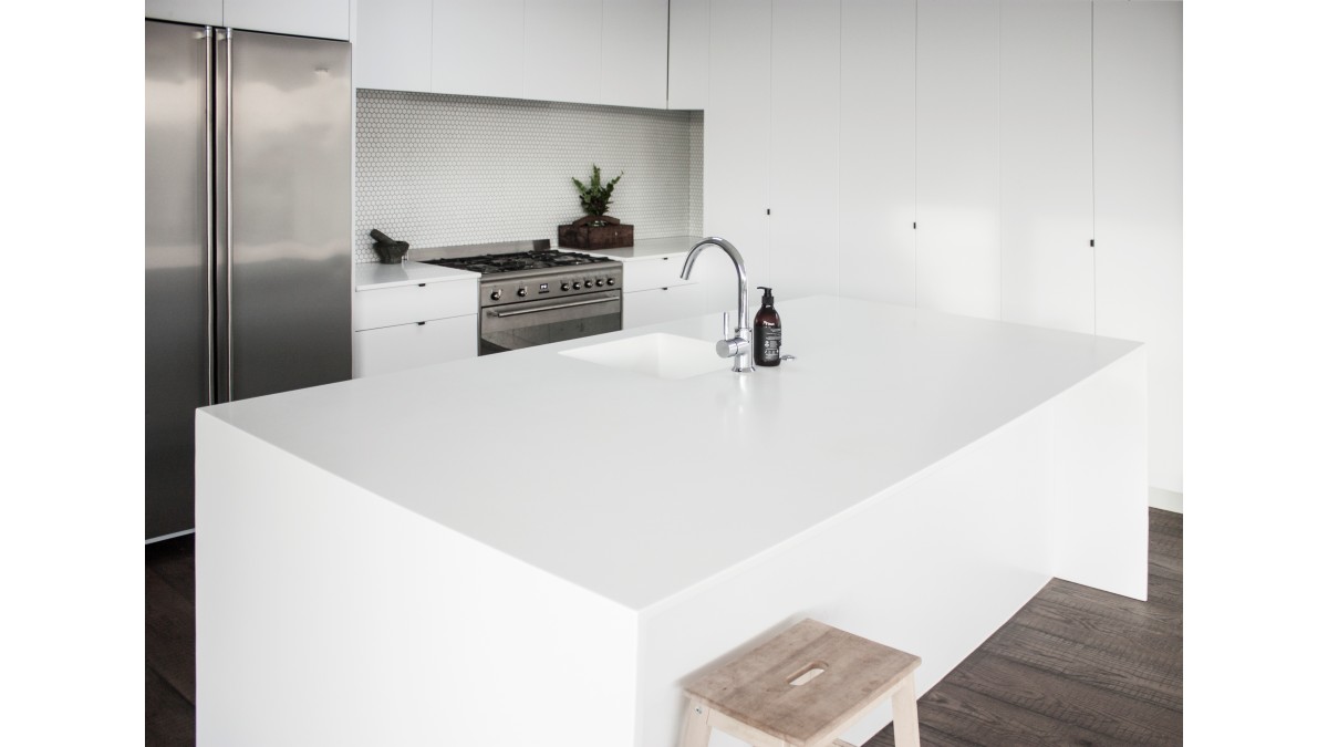Corian Glacier White kitchen featuring 19mm thick sheets and an integrated PURE Corian 965 sink, designed by Maggie McGuire.