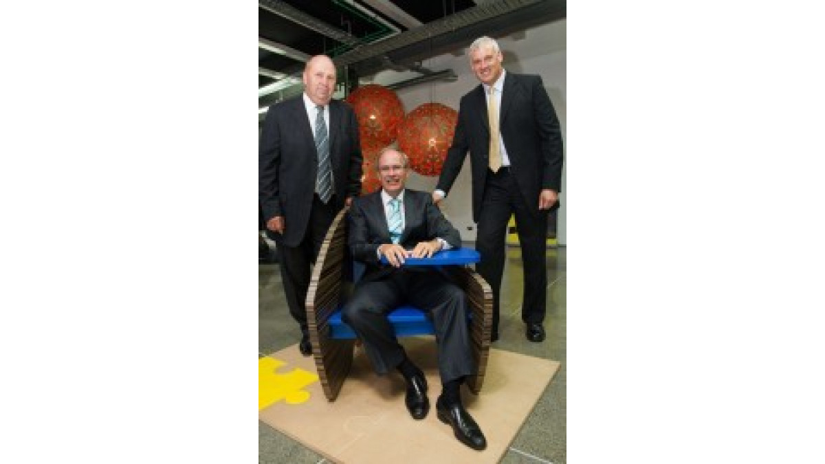 Auckland Mayor Len Brown tries the J Chair, flanked by Paul Duffy and Laminex Group General Manager Robert Gibbes.