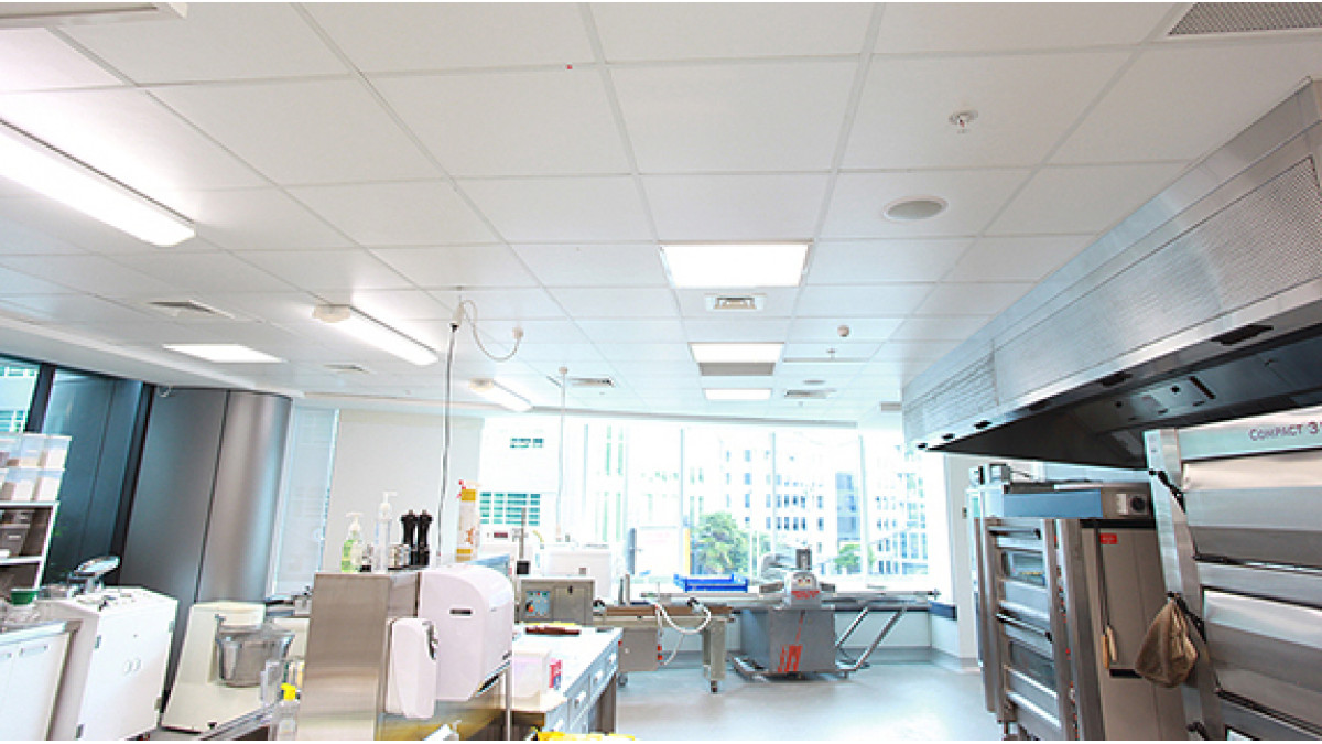 The Goodman Fielder food tech room, a busy training centre in the heart of Auckland city where 600 x 600 mm ceiling panels were fixed on a standard grid system, creating a clean and smooth monolithic look that also controls the reverberation and noise from a busy kitchen.
